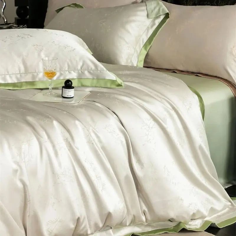 White luxury lyocell eucalyptus bedding set with light green accents and a small bottle on the duvet.