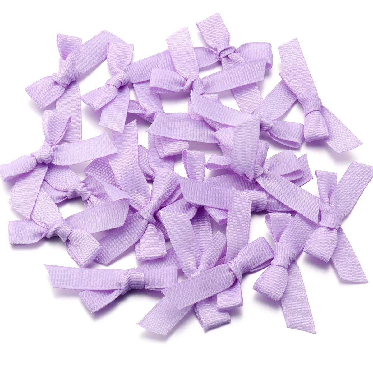 A pile of light purple satin ribbon bows for craft and decoration.
