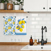 A set of two blue-edged lemon kitchen towels hanging on a rack above a white sink.