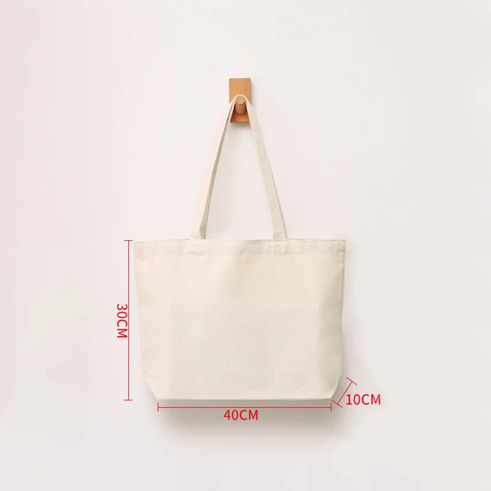 A beige canvas tote bag with wooden handles is shown against a white background.