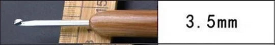 A close-up of a wooden handle and silver tip of a crochet knitting needle, labeled as 3.5mm.