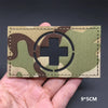 A tactical patch featuring a medical cross symbol on a camouflage fabric background.