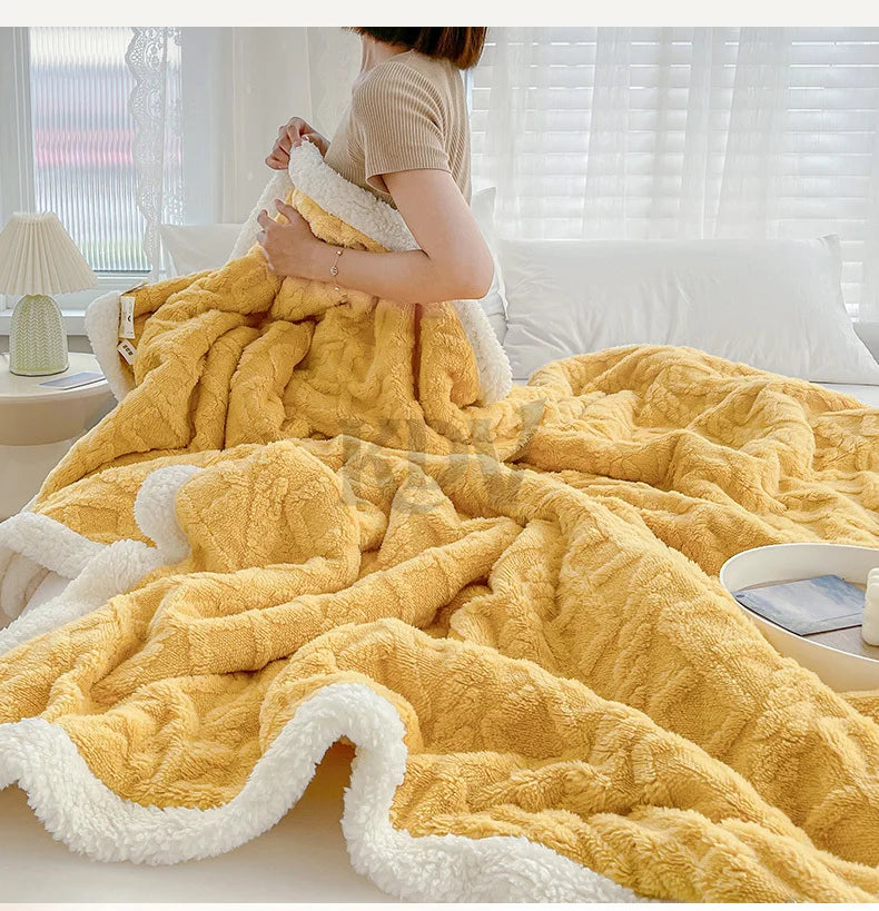 A thick yellow fleece blanket with white trim is draped on a bed, shown from the back.