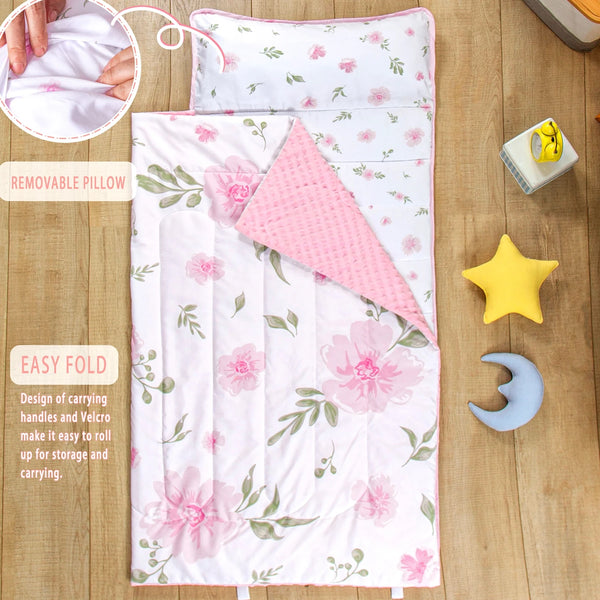 A pink and green patterned toddler nap mat with a removable pillow and blanket set shown on a wooden surface.