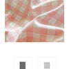Close-up of a pink and white checkered fabric texture showing soft folds and drape.