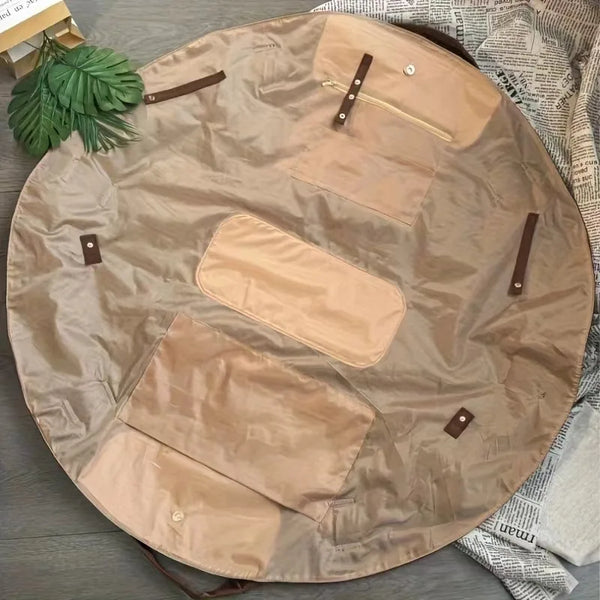 A tan foldable tote bag with light brown accents is shown lying flat on a dark surface.