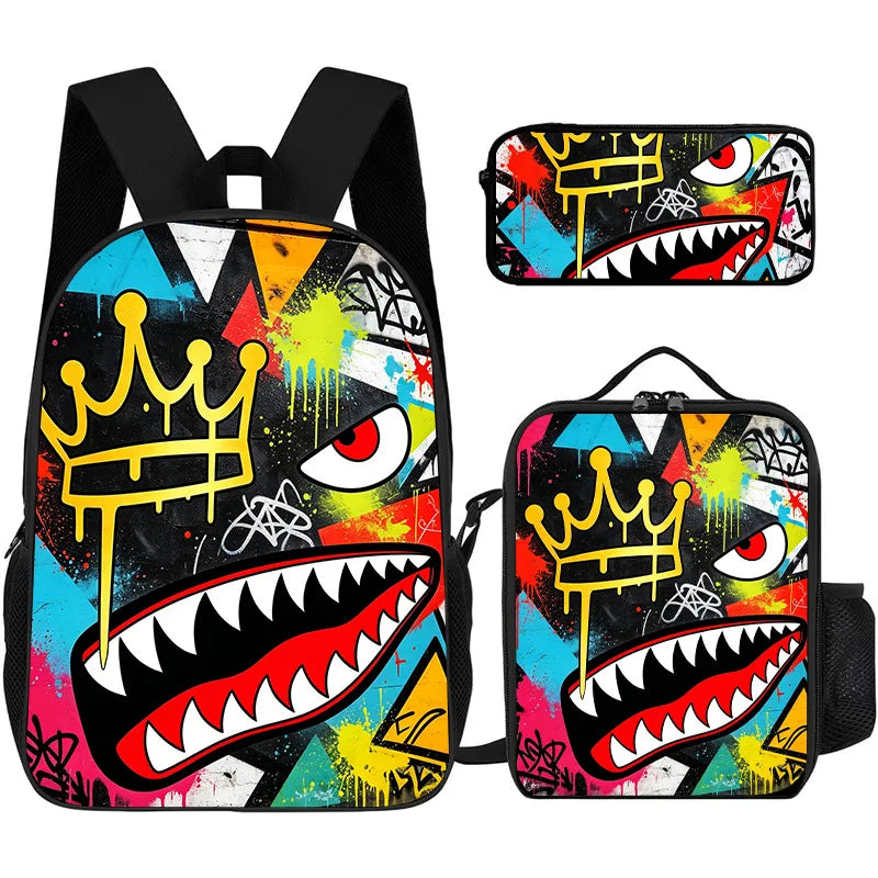 A set of three graphic print backpacks featuring a vibrant, dark, and colorful design with crowns and fierce teeth.
