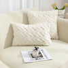A white, textured geometric plush throw pillow resting on a light-colored sofa.
