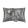 A smooth, gray satin silk pillow cover is shown folded and draped.
