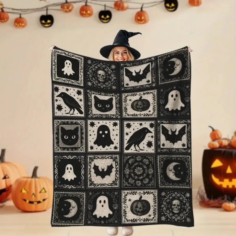 A black flannel patchwork throw blanket featuring various spooky Halloween designs like bats ghosts and pumpkins.