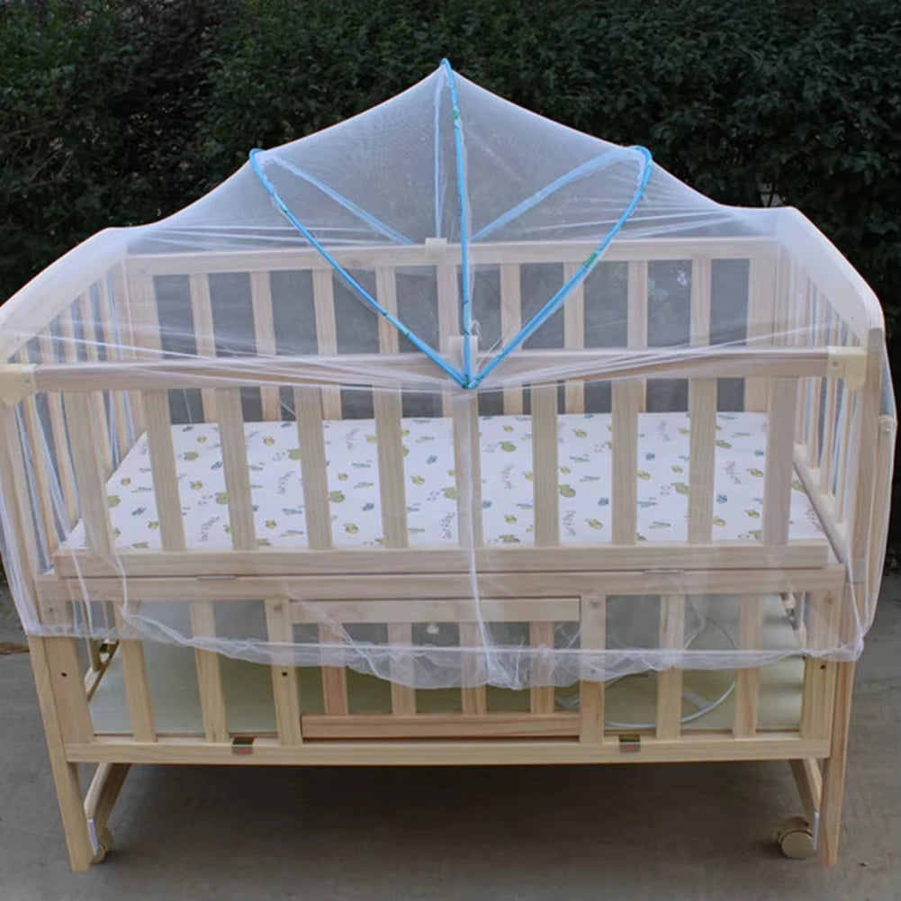 A wooden crib covered with a sheer mosquito net for protection.