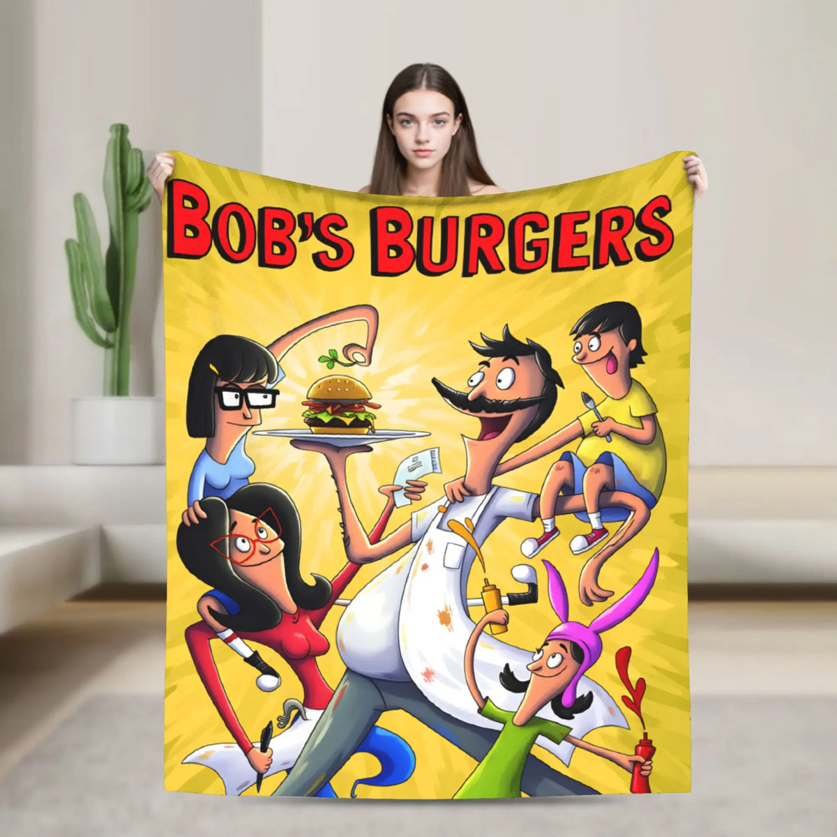 A colorful throw blanket featuring a cartoon illustration of a family preparing burgers.
