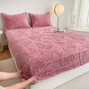A pink jacquard weave fitted sheet bedding spread on a white bed with a rabbit figurine nearby.