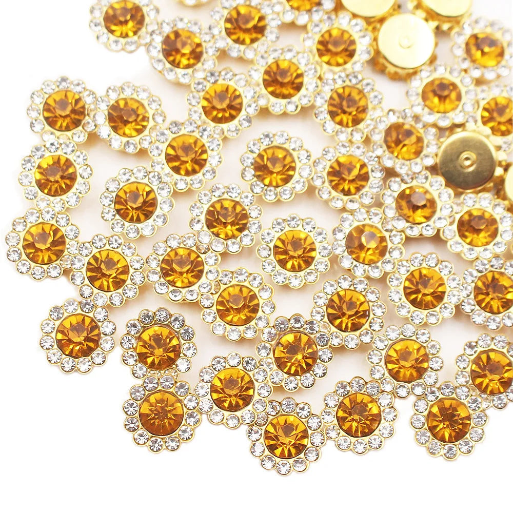 A close-up of sunflower crystal rhinestone sew-on buttons in gold and clear tones.
