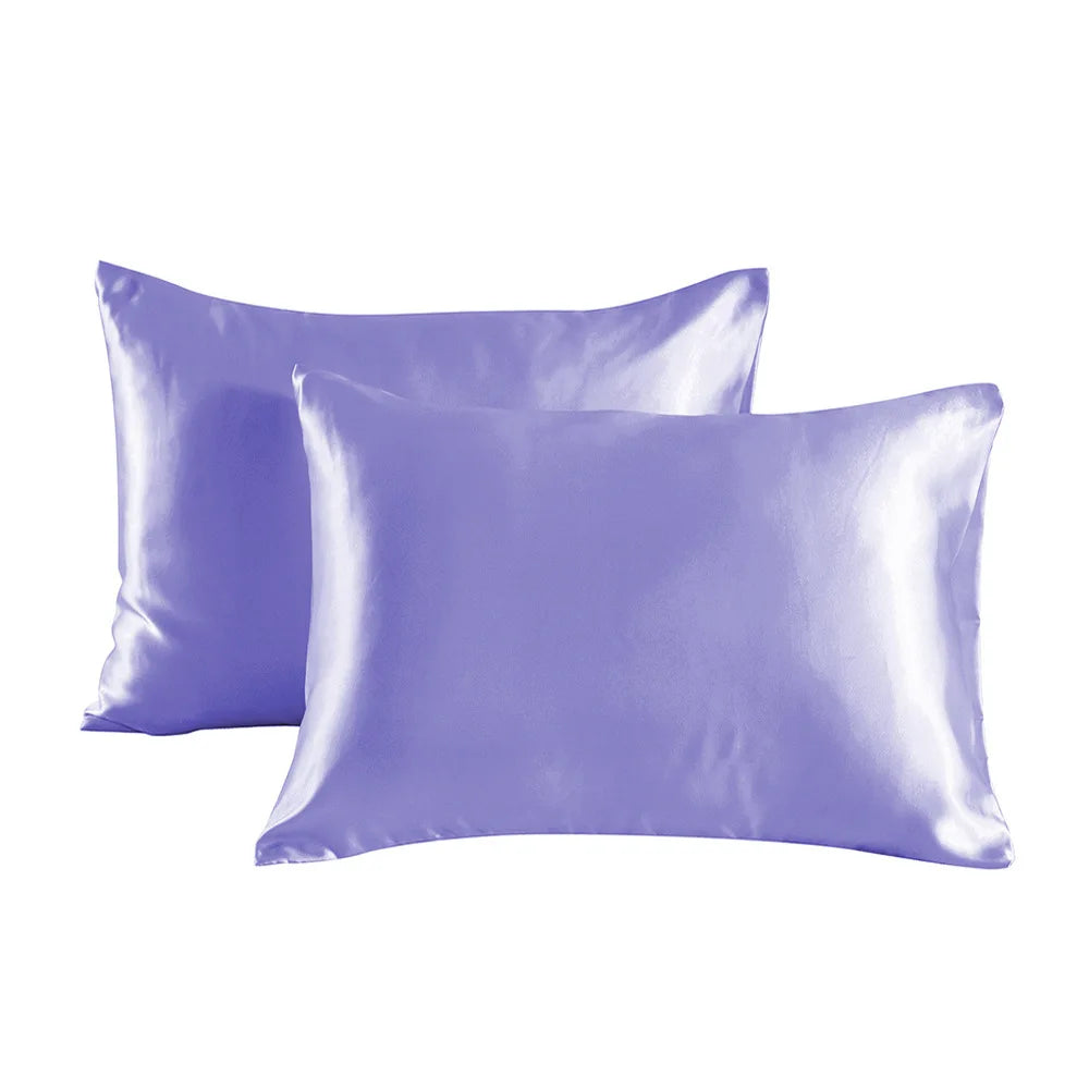 A pair of smooth, lavender satin pillowcases lying flat against a white background.