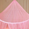 Pink sheer dome mosquito net for beds, draped over a light-colored wooden structure.