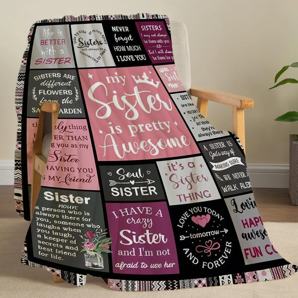 A patterned flannel throw blanket featuring text about sisters and love.