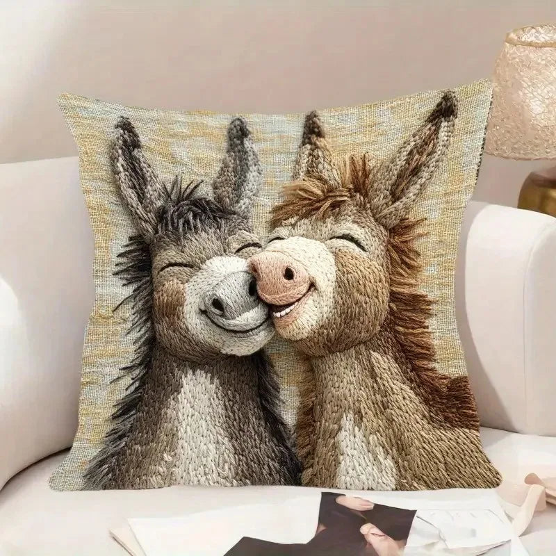 A decorative pillow cover featuring a realistic cartoon illustration of two affectionate donkeys.