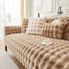 A beige plush rabbit fur sofa cushion cover draped over a sofa with light curtains and white decor.