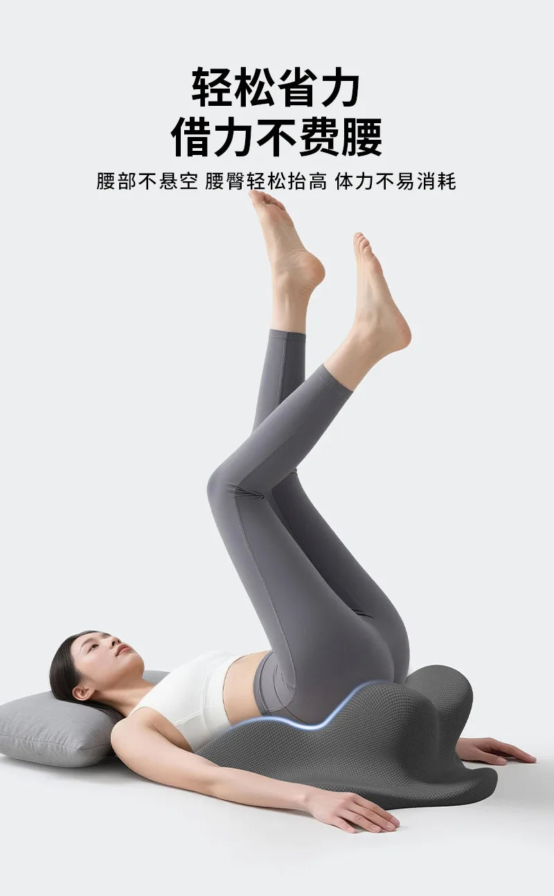 A person lying down with their legs raised, using a gray ergonomic memory foam leg/back support product.