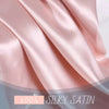 Close-up of a smooth pink satin silk fabric draped softly.