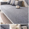Gray woven sofa cushion cover with beige accents and a white cup on a light-colored fabric.