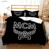 Black duvet cover set with white embroidered MCM logo on pillows and a matching blanket