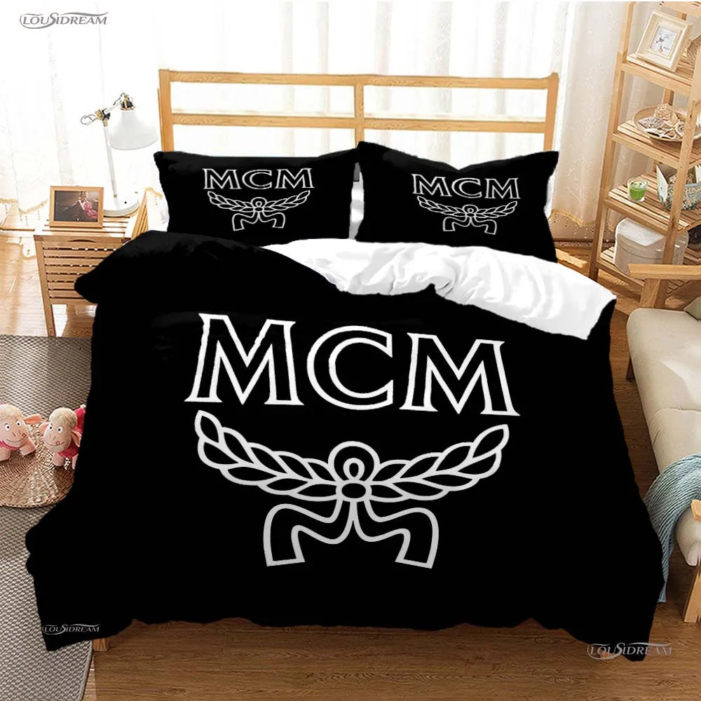 Black duvet cover set with white embroidered MCM logo on pillows and a matching blanket