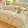 A light beige floral printed bedding set with matching pillows and a decorative arrangement on a bed.