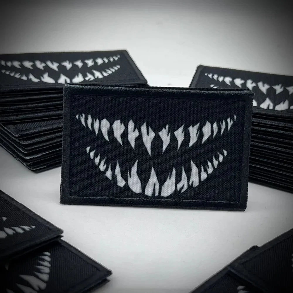A collection of black tactical hook and loop emblem patches featuring white flame designs.