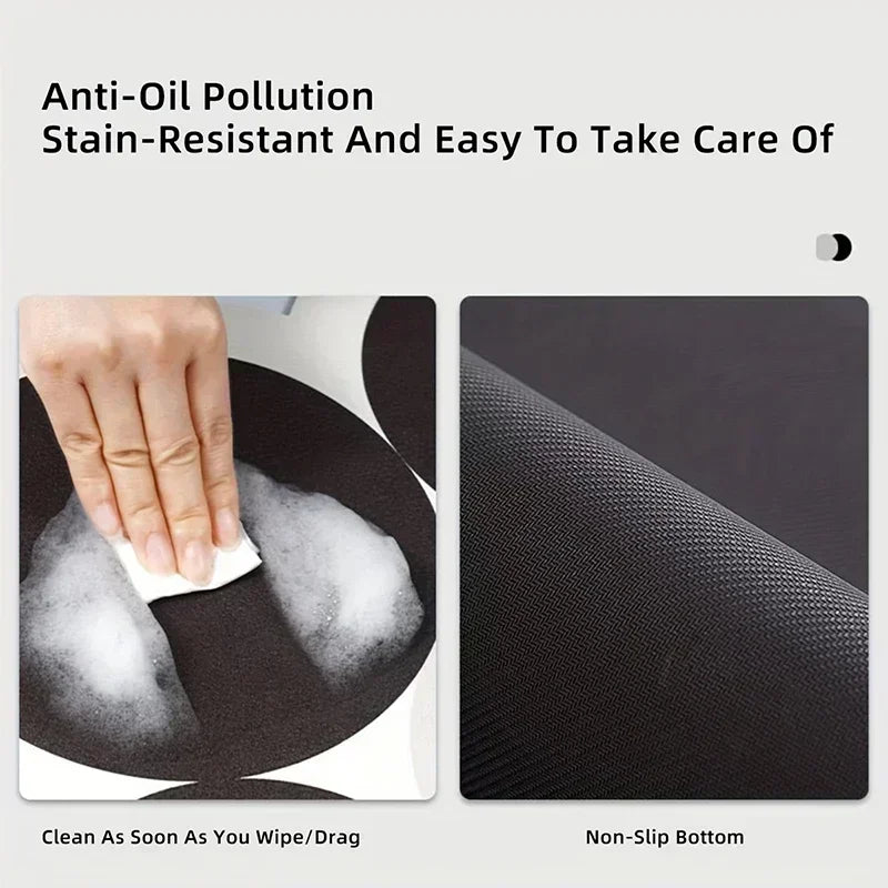 Close-up of a black non-slip dish drying mat showing its texture and a hand wiping it clean.
