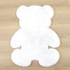 A white plush bear-shaped non-slip area rug lying on a wooden floor.