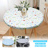 Round elastic-edged vinyl tablecloth displayed on a wooden table with a floral centerpiece.