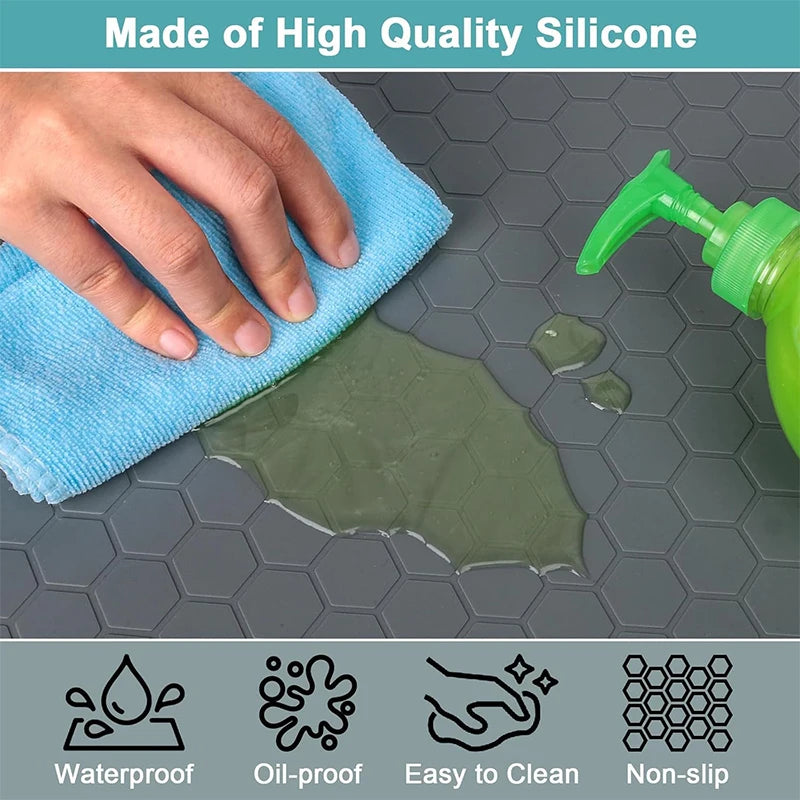 A hand is wiping a green silicone mat on a gray surface, demonstrating waterproof, oil-proof, easy-to-clean, and non-slip fea