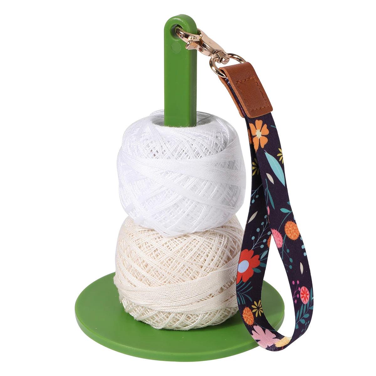 A green yarn holder with a brown leather strap and a white yarn winder.