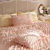 Pink ruffled cotton bedding set with white headboard and pillows