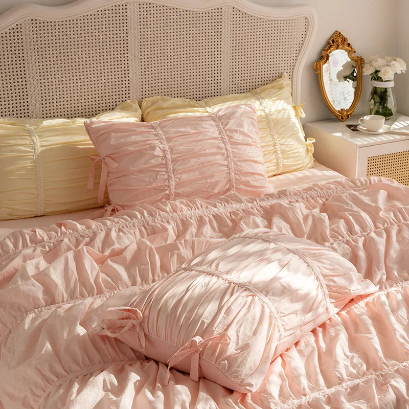 Pink ruffled cotton bedding set with white headboard and pillows