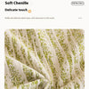 Close-up of a soft chenille fabric blanket with vertical stripes and scattered green flecks.