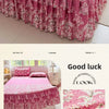 Pink floral print bed skirt set featuring pink and white patterns on a bed with a pink duvet.