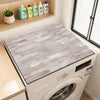 A white wood grain fridge cover mat is displayed inside a white washing machine.