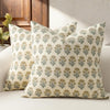 A beige throw pillow cover with a repeating pattern of olive green and gold floral motifs.