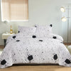 A white duvet cover set with a black marble print pattern displayed on a bed.