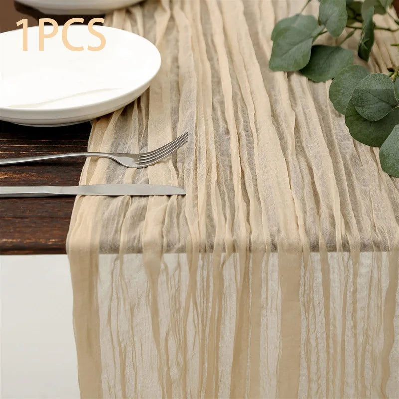 A semi-sheer beige gauze table runner with vertical stripes is displayed next to a white plate and silverware.