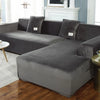 A gray velvet sofa cover for an L-shaped sectional sofa in a living room setting.