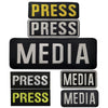 A stack of black and yellow embroidered patches with the word PRESS and MEDIA on them.
