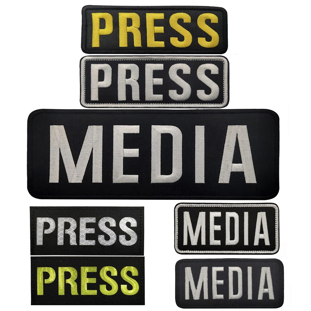 A stack of black and yellow embroidered patches with the word PRESS and MEDIA on them.