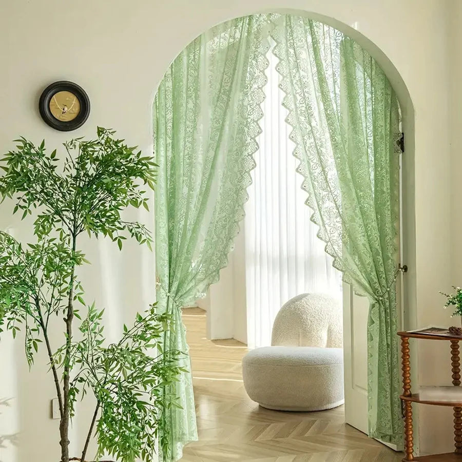 Light green lace curtain with a beaded phoenix tail design framing a window.