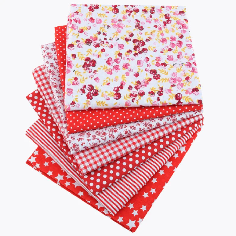 A stack of red, white, and pink floral dot pattern cotton fabric squares for DIY crafting.
