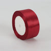 A roll of deep red satin ribbon, 4cm wide, used for crafts and gift wrapping.