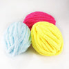 Three skeins of extra thick hand-knitted yarn in shades of pink, light blue, and yellow.